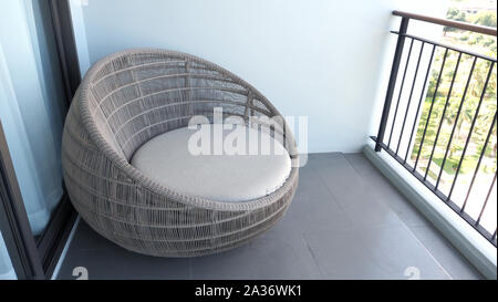 Outdoor beach chair on the hotel room balcony or terrace which made from natural wood called rattan and brown color round shape and look luxury for re Stock Photo