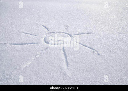 Smiling sun drawn on white snow on a frosty winter day. Stock Photo