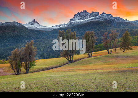 Picturesque autumn landscape with snowy peaks at sunset. Autumn rural landscape with colorful sunset near Cortina d Ampezzo touristic town, Dolomites, Stock Photo