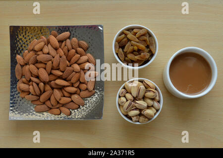 Roasted almond with sweet raisins and pistachios isolated on the wooden table Stock Photo