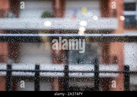 Many raindrops on a window glass on a blurry background Stock Photo