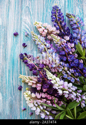 Pink and purple lupine flowers border on a old wooden background Stock Photo