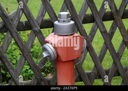 Typical red hydrant stands on the street Stock Photo