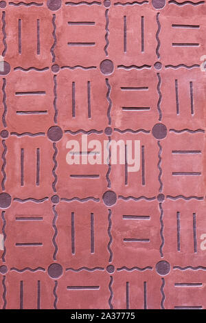 Background or texture of decorative pink wall with straight and wavy lines and circles pattern from a historic house, reddish, pinkish exterior facade Stock Photo