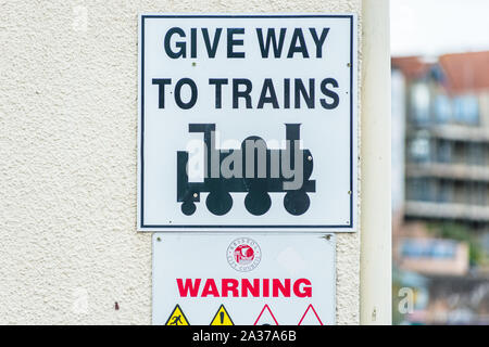 Give Way to Trains sign on Wapping Railway Wharf on Floating Harbour in Bristol, England, UK. Stock Photo