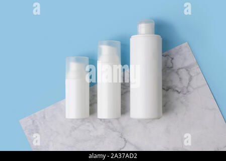 Minimal composition with cosmetic bottles on creative blue and marble background Stock Photo