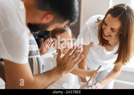 happy parents and their daughets doing domestic chores together. close up cropped photo Stock Photo