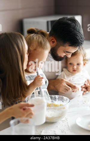 father and mother giving advice how to cook pancakes, close up cropped photo Stock Photo