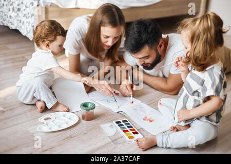 young parents studing with children , developing their painting skills, close up photo Stock Photo