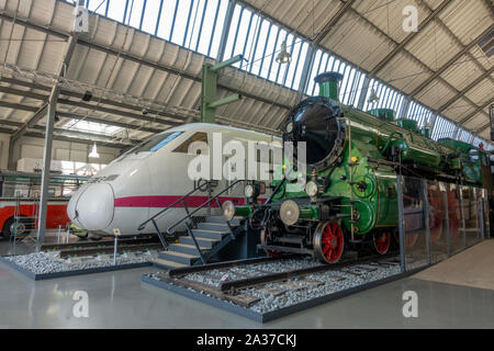 A J. A. Maffei Class S 3/6 steam locomotive (1912) and modern ICE-V (experimental) train side by side in theGerman Transport Museum, Munich, Germany. Stock Photo