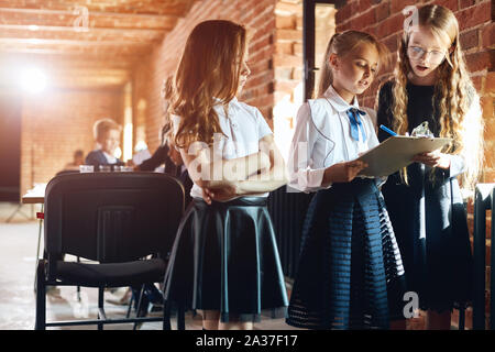 three girl in stylish formal clothes making notes, holding a notebook, analyzing documents. close up photo Stock Photo