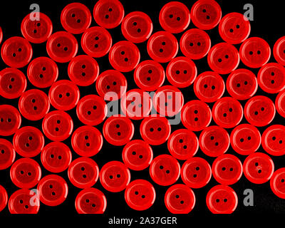 Red plastic buttons on black background Stock Photo