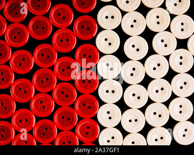 Red and white plastic buttons on black background Stock Photo