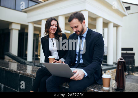 positive young co-workers drinking coffee, checking document,preparing a project. close up photo Stock Photo