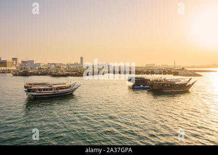 Dhow's in the sea looking towards Dhow Harbour on the Corniche at sunset, Doha, Qatar Stock Photo