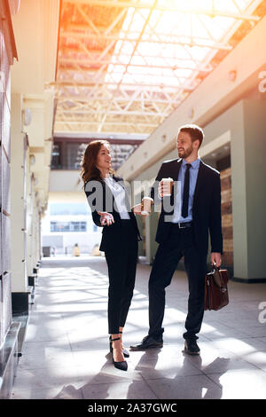 pleasant young employees laughing at funny situstion during the conference, full length photo. reaction, Stock Photo