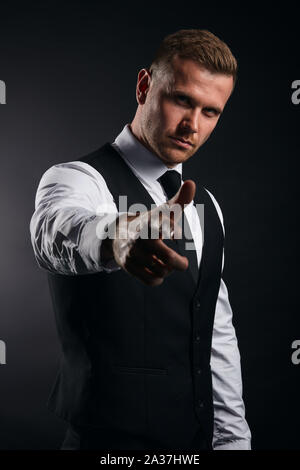 Handsome confident businessman pointing finger at the camera. isolated black background, studio shot. lifestyle, best choice. close up portrait. Stock Photo