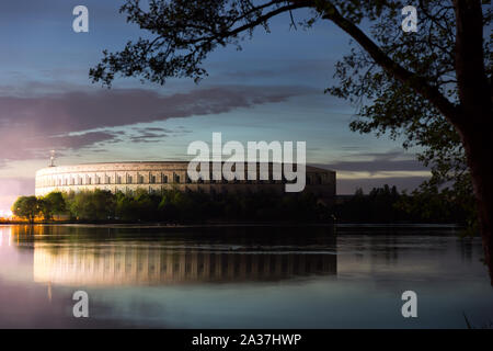 NÜRNBERG - Hitler's NSDAP Congress Hall illuminated at night by the adjoining amusement park. Stock Photo