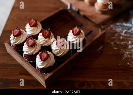 Set of delicious cupcakes on a kitchen table, to angle view. close up photo. yummy treatment for guests Stock Photo
