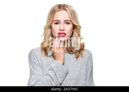 Young Woman Suffering From Toothache. Tooth Pain And Dentistry background. Beautiful Young Woman Suffering From Terrible Teeth Pain, Touching Cheek Wi Stock Photo