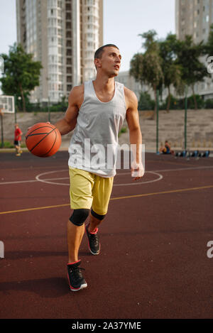 Basketball player goes on throw, outdoor court Stock Photo