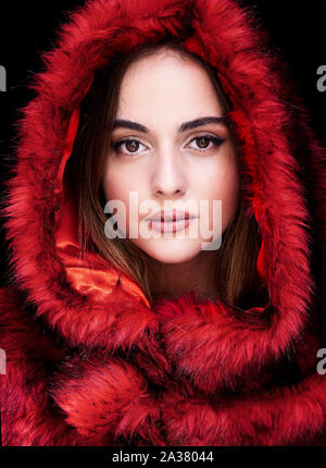 Beautiful young woman wearing red fur coat Stock Photo