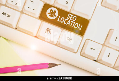Word writing text Seo Location. Business photo showcasing process to optimize pages on your site to show for organic White pc keyboard with empty note Stock Photo
