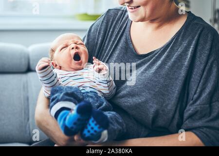 Mother with newborn. Woman holding her 4 days old son at home.