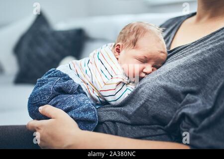 Mother with newborn. Woman holding her 4 days old son at home. Stock Photo