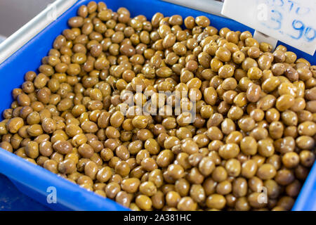 Traditional greek food ingredient, green olives in box on farmer market close up Stock Photo