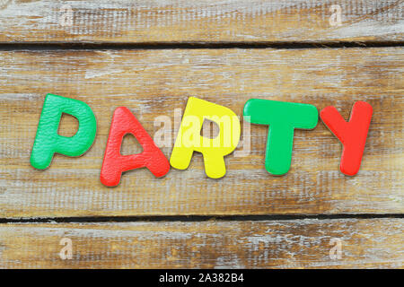 Word party written with vivid, colorful letters on rustic wooden surface Stock Photo