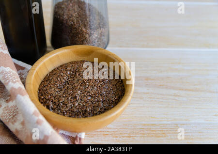 Brown flax seeds  in wooden bowl  and flaxseed oil on a rustic table. Superfood linseeds background with copy space. Healthy eating ,vegan diet concep Stock Photo