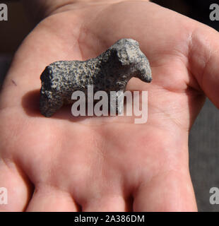 En Esur, Israel. 06th Oct, 2019. A man holds an animal figurine, discovered during excavations of a vast 5,000 cosmopolitan and planned city from the Early Bronze Age, one of the first and largest of the ancient Near East, excavated by the Israeli Antiquities Authority in En Esur, Israel, on Sunday, October 6, 2019. The En Esur archaeological site, located near Wadi Ara, was discovered prior to the construction of a highway interchange and revealed a massive city where 6,000 people lived. Photo by Debbie Hill/UPI Credit: UPI/Alamy Live News Stock Photo