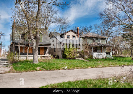 DETROIT, MICHIGAN - APRIL 27, 2019:  Three old houses have been abandoned and are gradually falling apart in a Detoit neighborhood. Stock Photo