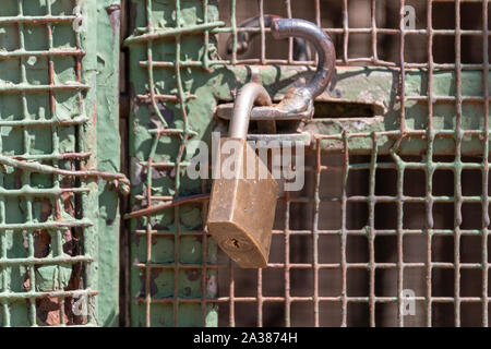 A close up view of a padlock keeping a metal gate closed Stock Photo