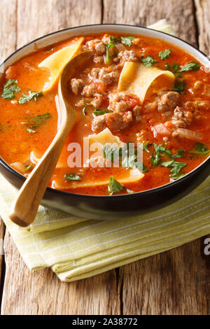 Tomato lasagna soup with minced meat closeup in a plate on the table. vertical Stock Photo