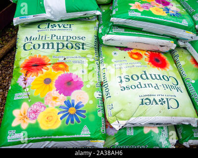 A Stack Of Bags Of Clover Brand Container Compost In A Garden