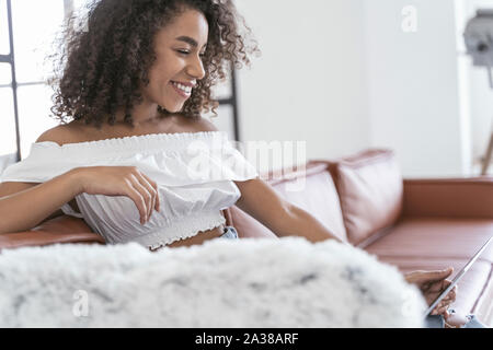 Cheerful woman talking to her friend on Internet Stock Photo