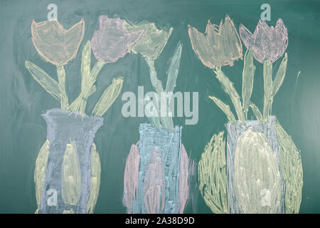 Children's chalk drawing of tulips on a blackboard Stock Photo