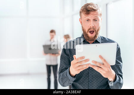 surprised businessman reading SMS on his tablet Stock Photo