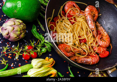 Italian pasta with tiger prawns or shrimps with vegetables. Mediterranean food concept. Stock Photo