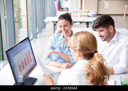 Shot of investment advisor businesswoman consulting with young couple while sitting in the office and analyzing financial statements Stock Photo