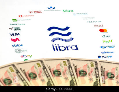 Libra Association logo on paper brochure and US dollar banknotes. Illustrative for Facebook plan to create global currency called Libra. Stock Photo