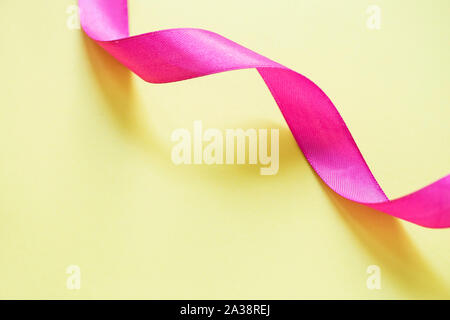 Pink ribbon on yellow background Stock Photo