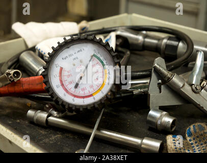 Pressure gauge and other working tools on a car service desk Stock Photo
