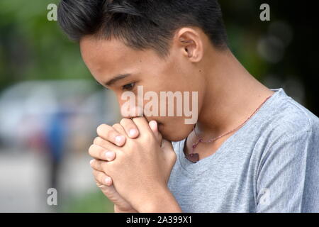 A Praying Asian Boy Teenager Stock Photo