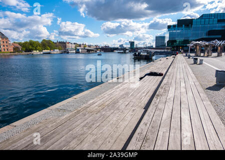 Copenhagen, Denmark - May 04, 2019: People relax on one of the waterfronts near the BLOX - Danish Architecture Center in Copenhagen