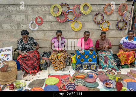 Women making bead work at the Maasai Market, central Arusha, Tanzania Stock Photo