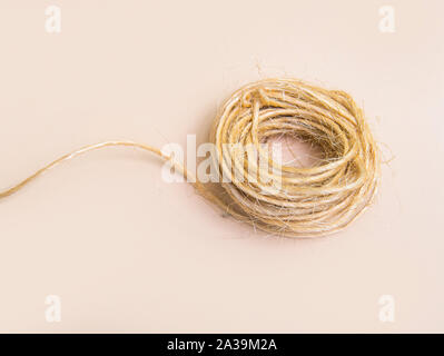Skein of jute twine isolated on light beige natural background Stock Photo