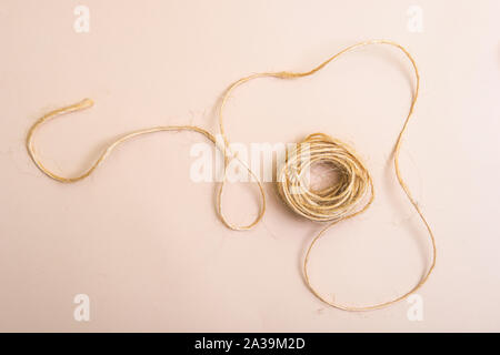 Skein of jute twine isolated on light beige natural background Stock Photo
